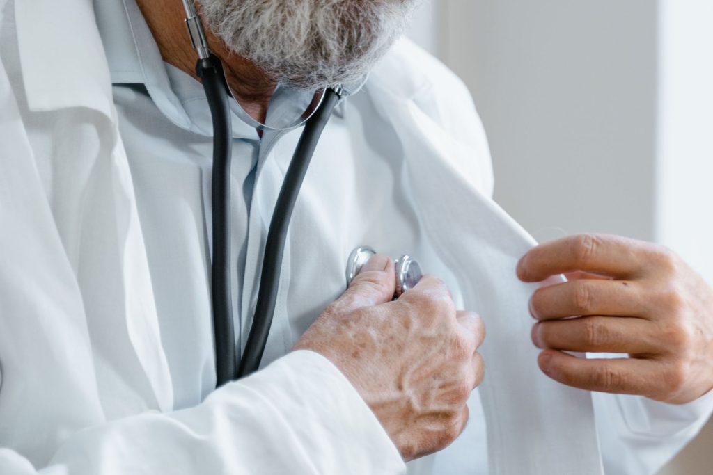 Close-up of a doctor adjusting a stethoscope while in a medical consultation. — Dr Andrew Hummel - Advancing Healthcare Throu