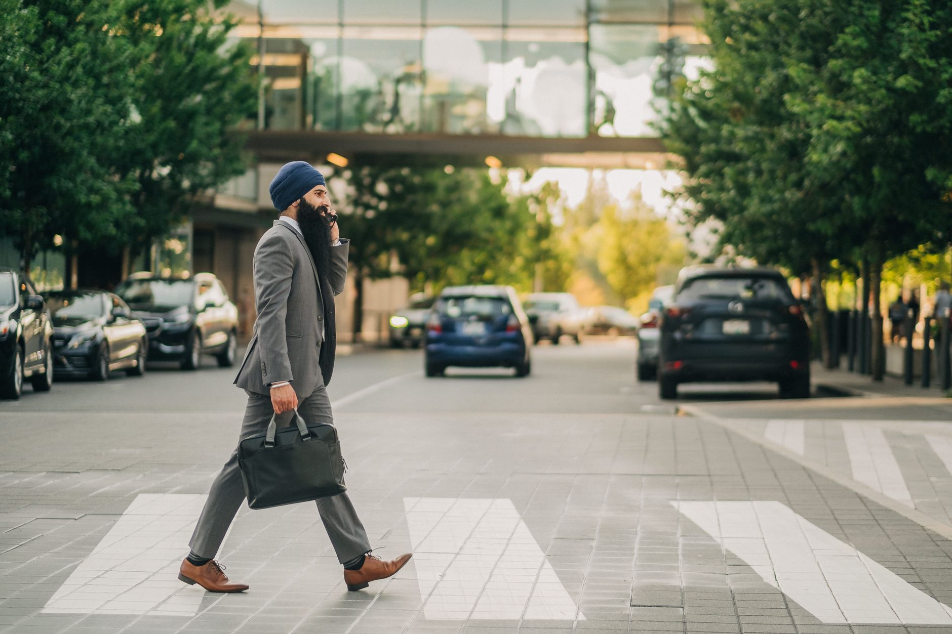 Sikh businessman with a turban crossing a city street on a zebra crossing, carrying a briefcase. — Optimizing Testosterone Le