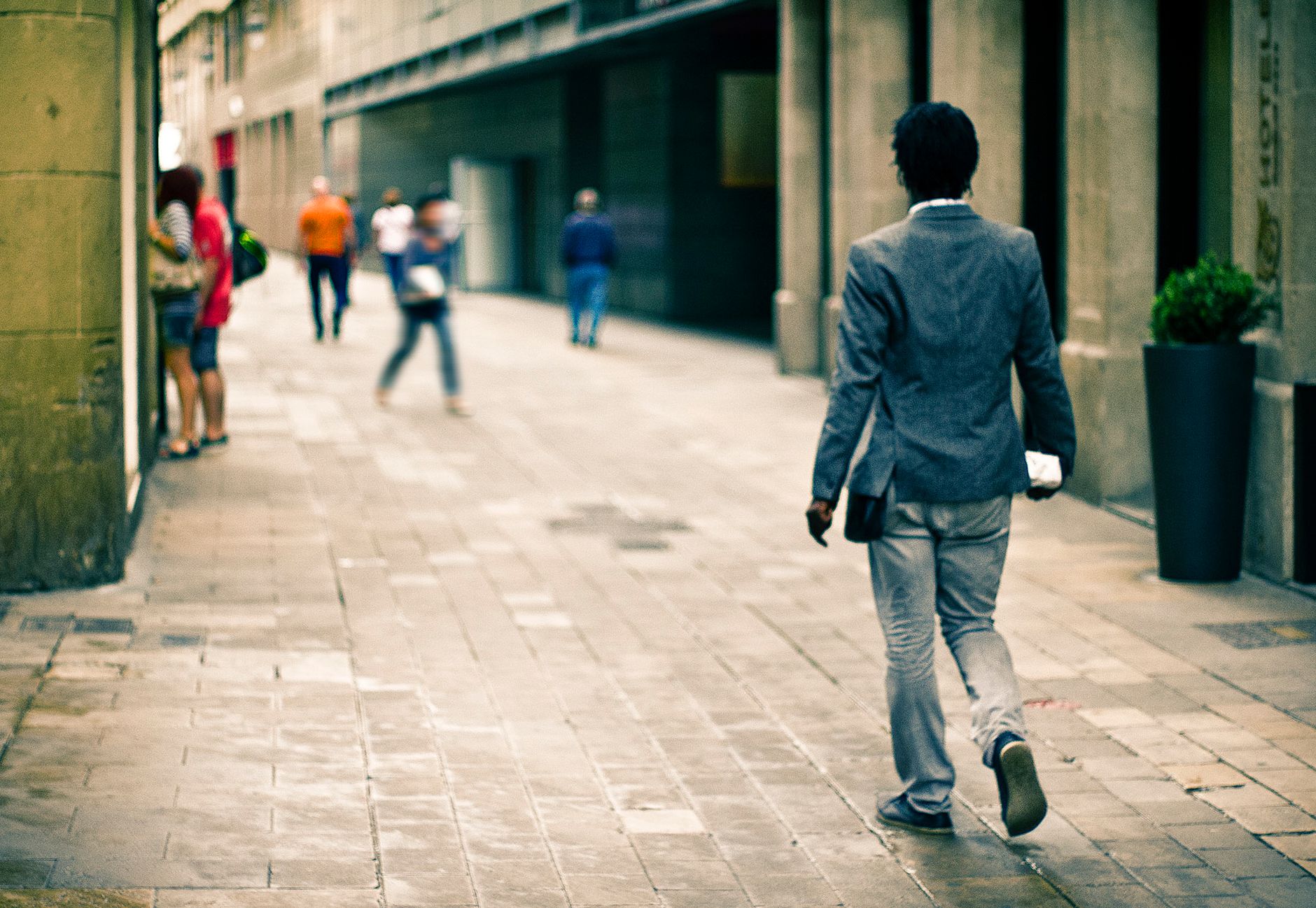 A man in a suit walks through a city alley, reflecting urban life and fashion. — Speak Your Heart: The Beauty of an Audio Gue