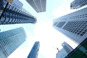 A striking upward view of various skyscrapers in an urban setting against a clear sky. — The Advantages of Trading with Futur