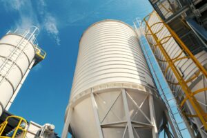 View of industrial storage silos against a clear blue sky