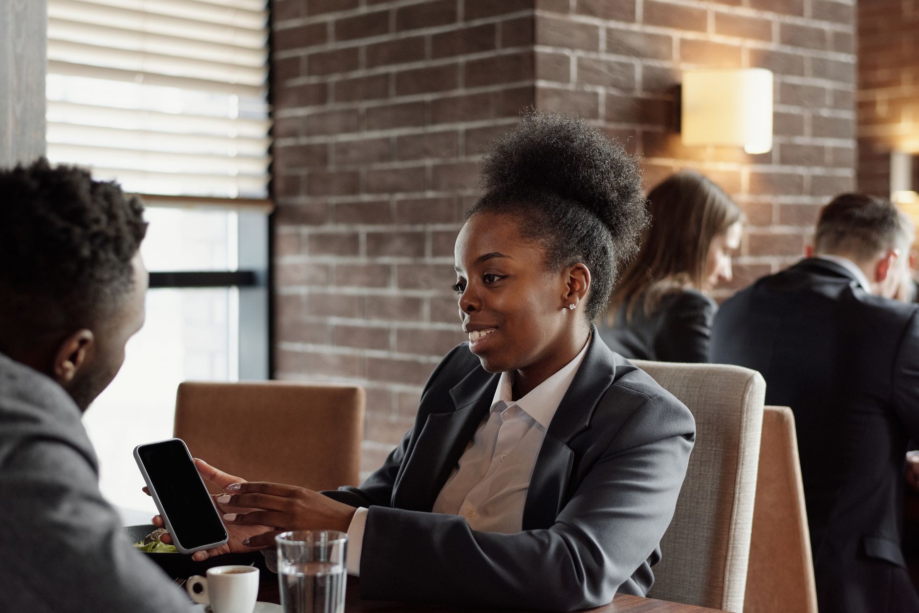 Two professionals in suits chatting over coffee during a lunch break at a café. — The Ultimate Guide to Buying Cannabis Seeds