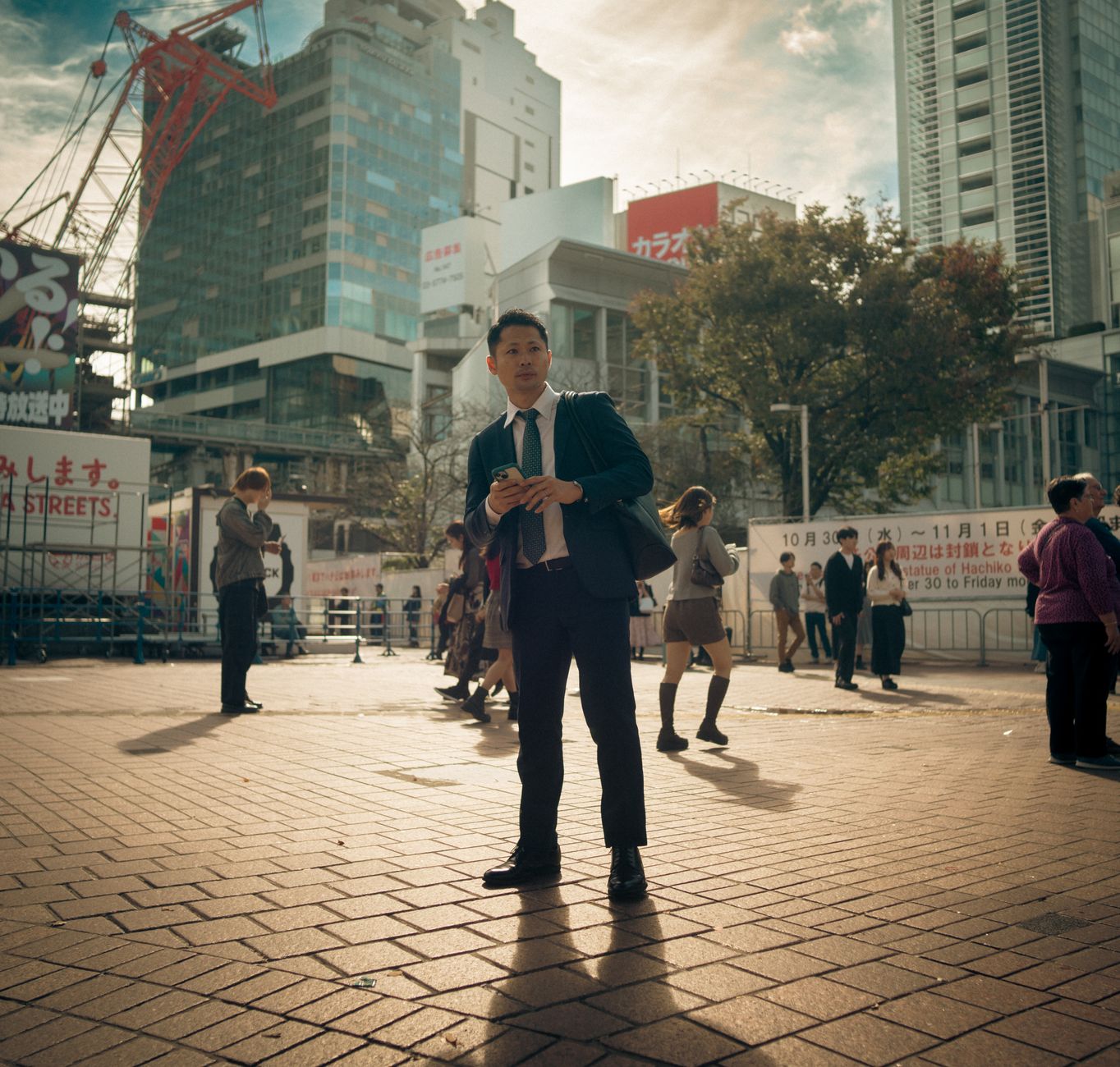 Businessman standing in Shibuya Tokyo with busy urban backdrop and people walking by. — Why You Should Visit Rexas.com for Yo
